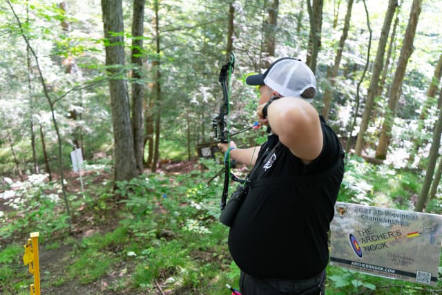 Archer aiming at target in forest