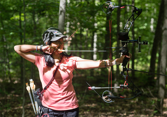 Archer aiming at target in forest